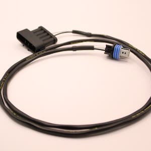 Puede incluir: Un cable eléctrico negro con un conector negro en un extremo y un conector azul en el otro extremo. El cable está enrollado y listo para usar.