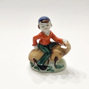 May include: A white ceramic mug with a black handle and the text "But First, Coffee" in a black, bold font. The mug is on a white surface. The mug is 4 inches tall.