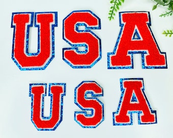 May include: Red felt letters spelling "USA" with a blue outline. The letters are in a vintage style and have a fuzzy texture.