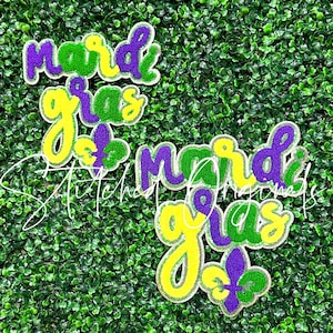 May include: Two Mardi Gras themed patches with the words "Mardi Gras" in green, yellow, and purple glitter. Each patch features a fleur-de-lis.