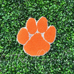 May include: Orange and white glitter paw print iron-on patch.