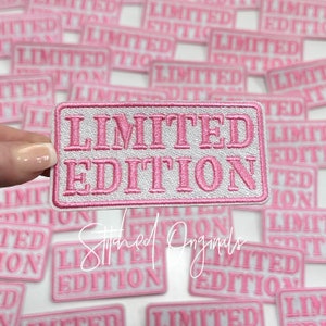 May include: A close-up of a pink and white embroidered patch that says "Limited Edition". The patch is surrounded by other similar patches.
