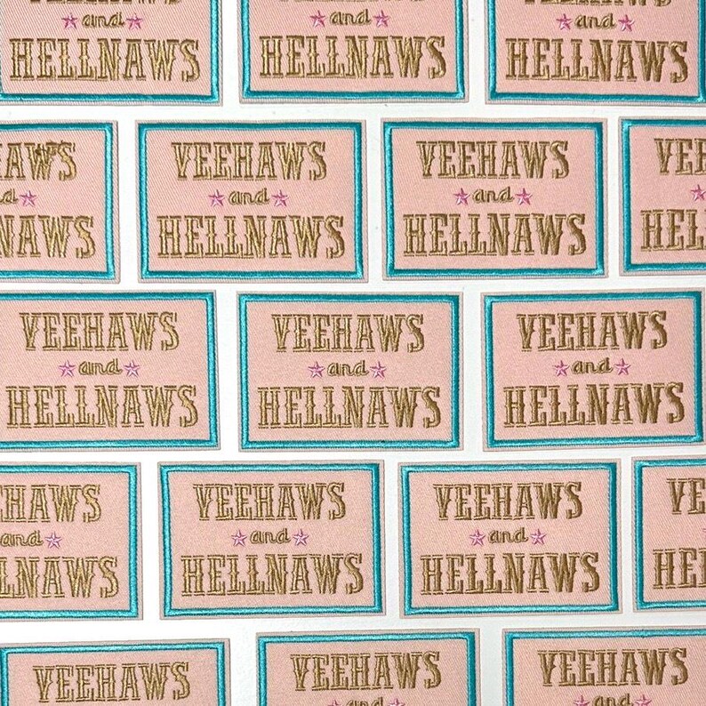 Op de afbeelding: Een verzameling roze en witte geborduurde patches met de tekst "Yeehaws and Hellnaws" in gouden letters. De patches hebben een turquoise rand.