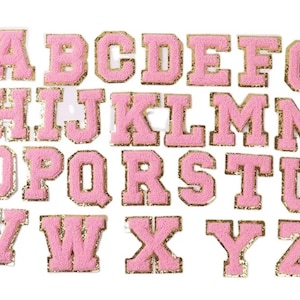 May include: A set of pink felt letters with gold glitter trim. The letters are in uppercase and are arranged in alphabetical order.