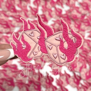 May include: Pink embroidered iron-on patch with two dice with hearts on each side, engulfed in flames.