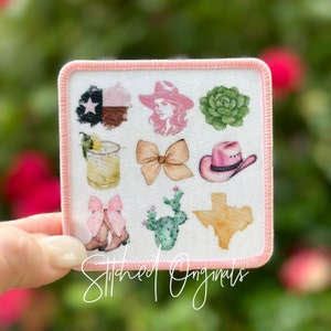 May include: A pink square patch with a white background and nine different images. The images include a Texas flag, a woman wearing a cowboy hat, a succulent, a margarita, a bow, a cowboy hat, a pair of cowboy boots with bows, a cactus, and a watercolor outline of the state of Texas.
