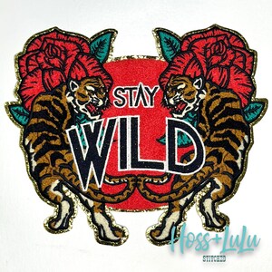 May include: A gold embroidered patch featuring two tigers, roses, and the text "Stay Wild".