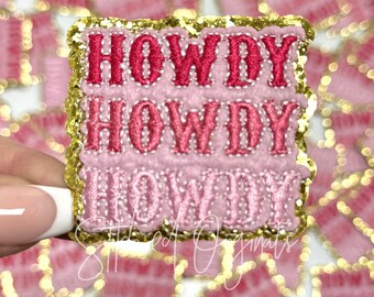 May include: Pink and gold iron-on patch with the text "Howdy" repeated three times.