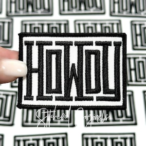 May include: A rectangular black and white patch with the word "HOWL" in bold, stylized letters. The patch has a black border and is held by a hand. The background features a pattern of similar patches. The text "Stitched Originals" is at the bottom.