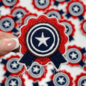 May include: Red, white, and blue embroidered patch with a star in the center. The patch is shaped like a circle with a ribbon around it. The patch is surrounded by other similar patches.