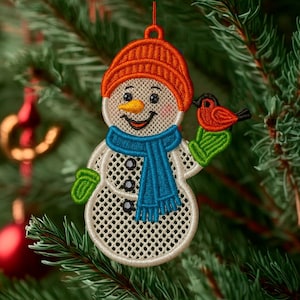 May include: Embroidered snowman Christmas ornament with an orange knit cap, blue scarf, and green mittens. The snowman has a carrot nose and is holding a red bird. The ornament is hanging on a Christmas tree.