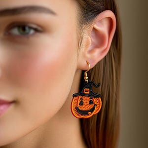 May include: A pair of Halloween-themed earrings. Each earring features an orange pumpkin with a smiling face and a black witch hat. The earrings have gold-colored hooks.