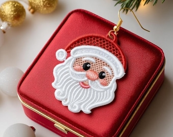 May include: A red satin jewelry box with a gold clasp and a Santa Claus earring. The Santa earring is an embroidered design with a white beard and hat trim, a red hat, and a gold earring hook. Christmas-themed jewelry.