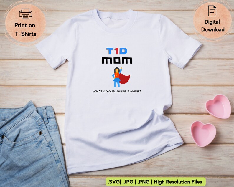 Puede incluir: Camiseta blanca con un gr&aacute;fico negro que dice "T1D MOM" y presenta una mujer superh&eacute;roe de dibujos animados. El texto debajo del gr&aacute;fico dice "&iquest;Cu&aacute;l es tu superpoder?"
