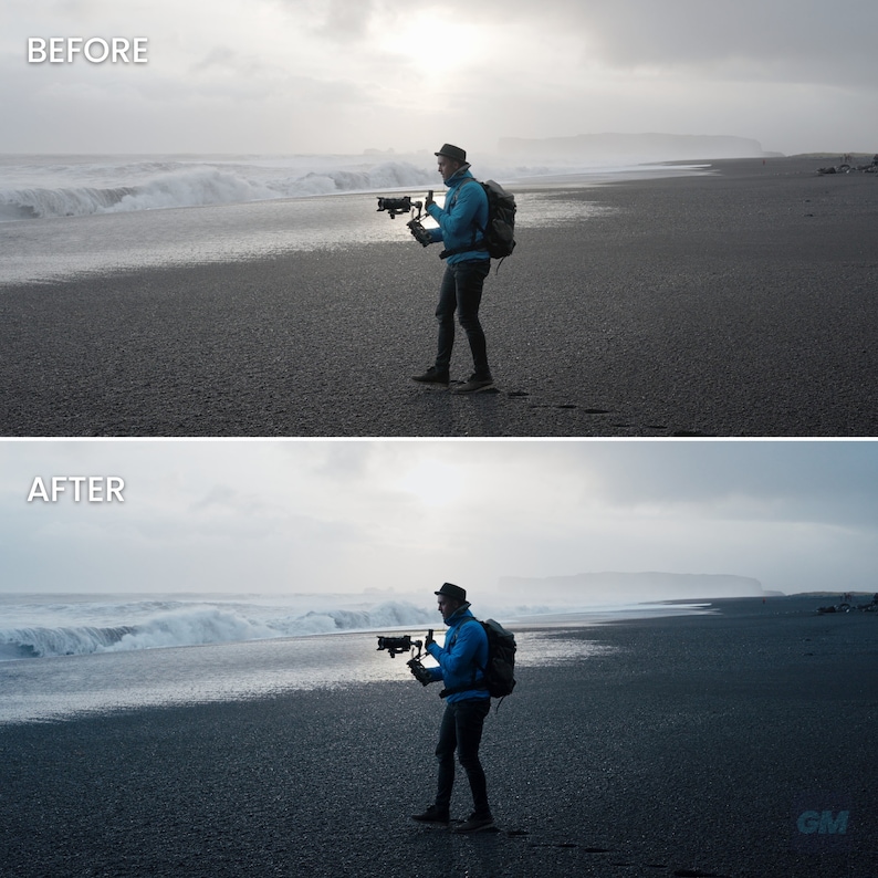 May include: A person wearing a blue jacket and a hat is standing on a black sand beach, holding a camera with a stabilizer. The person is looking at the camera and the background is a cloudy sky and a large wave.