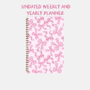 May include: An undated weekly and yearly planner with a pink background and a pattern of pink bows.