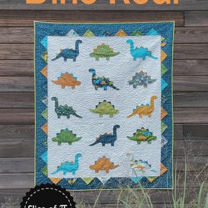 May include: A handmade quilt featuring colorful dinosaur appliqués on a white background. The quilt has a blue border with a geometric pattern and a green binding. The words "Dino Roar" are displayed above the quilt.
