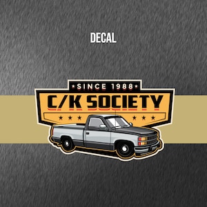 May include: A black and gray pickup truck decal with the text "C/K SOCIETY" and "SINCE 1988" in white. The decal is on a yellow and gray background.