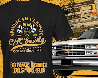 May include: A black t-shirt with a yellow graphic design featuring a vintage truck, checkered flags, and the text "American Classic C/K Society OBS Life Since 1988 Chevy I GMC OBS '88-98".