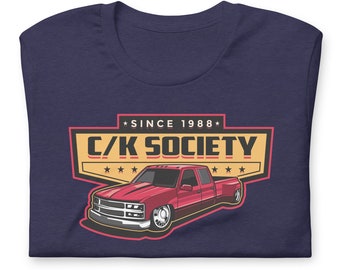 May include: A navy blue t-shirt with a vintage-style graphic of a red pickup truck. The graphic includes the text "C/K SOCIETY" and "SINCE 1988".