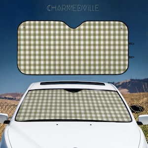 May include: A car sunshade with a green and white gingham pattern. The sunshade is displayed above a white car, with the same pattern visible in the car's windshield. The top of the image has the text "CHARMEDVILLE" and "www.CHARMEDVILLE.com".