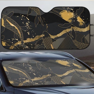May include: Black car sunshade with a gold and black koi fish design. The sunshade is made of a lightweight material and is designed to block out the sun's rays.