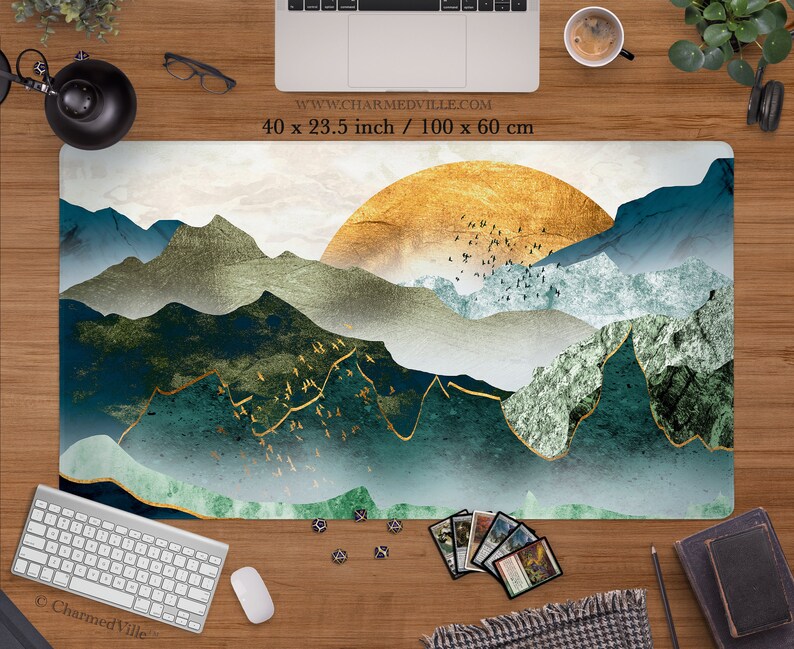 May include: A green, blue, and gold abstract mountain landscape with a golden sun in the background. The design is printed on a white background. The text "www.charmedville.com" and "40 x 23.5 inch / 100 x 60 cm" is printed in black at the top of the image.