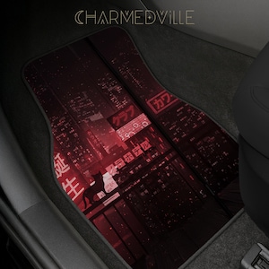 Könnte beinhalten: Auto-Fußmatten mit einem rot-schwarzen Stadtlandschaftsdesign. Die Matten zeigen eine Silhouette eines Hundes und japanischen Text. Das Wort "CHARMEDVILLE" ist oben aufgedruckt.