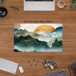 May include: A green, gold, and white mountain landscape with a golden sun rising over the peaks. The design is printed on a 24 x 14 inch mousepad. The text "www.charmedville.com" is printed in the top right corner of the mousepad.