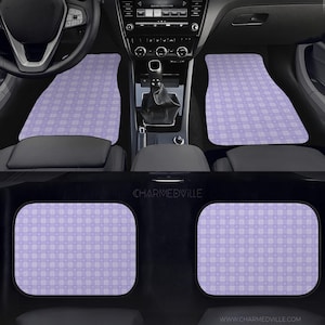 May include: Car floor mats with a lavender and white checkered pattern. The mats are visible in the front and back of a car. The car interior is black with a steering wheel, gear shift, and dashboard.