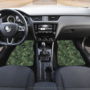 May include: A set of two car floor mats with a green and black design featuring a repeating pattern of black cats hiding in green foliage. The mats are made of a durable material and are designed to protect your car's interior from dirt and wear.