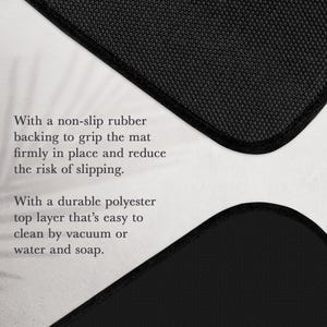 May include: A black floor mat featuring a textured non-slip rubber backing and a durable polyester top layer. The text reads: With a non-slip rubber backing to grip the mat firmly in place and reduce the risk of slipping. With a durable polyester top layer that's easy to clean by vacuum or water and soap.