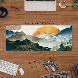 May include: A large, rectangular mousepad with a scenic landscape design. The design features a golden sunset over a mountain range with blue and green hues. The mousepad measures 31 inches by 12 inches, or 80 centimeters by 30 centimeters.