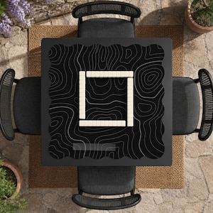 Pu&ograve; includere: Un tavolo quadrato nero con un motivo a linee topografiche bianche sulla superficie. Al centro del tavolo &egrave; disposta una composizione quadrata di tessere da gioco rettangolari color bianco sporco. Quattro sedie grigio scuro con schienali curvi lo circondano.