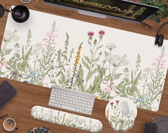 Può includere: Un tappetino da scrivania bianco con un design floreale che presenta vari fiori selvatici, tra cui cardi, margherite e felci. Il tappetino è abbinato a un tappetino per mouse e un poggiapolsi coordinati.
