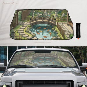 May include: Car windshield sunshade featuring a Japanese garden scene with a wooden bridge, koi fish, and stone lanterns. The artwork includes a pond, stepping stones, and lush greenery. The sunshade is black when folded.