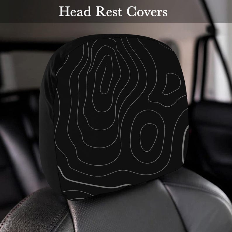 Peut inclure: Housse d'appui-t&ecirc;te noire avec un motif de carte topographique blanc. L'appui-t&ecirc;te est sur un si&egrave;ge de voiture noir. Le texte "Head Rest Covers" est en haut de l'image.