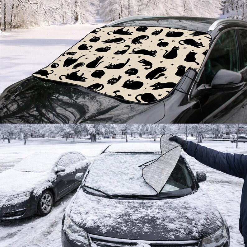 May include: A black car windshield cover with a beige background and a repeating pattern of black cat silhouettes in various poses. The cover is designed to protect the windshield from snow and ice. The image also shows a person removing the cover from a snow-covered car.
