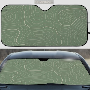May include: Green and white car sunshade with a topographic map pattern. The sunshade is designed to fit most car windscreens.