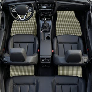 May include: A car interior featuring black leather seats and a steering wheel, equipped with custom floor mats that display a repeating olive green and white gingham check pattern across the front and rear footwell areas of the vehicle.