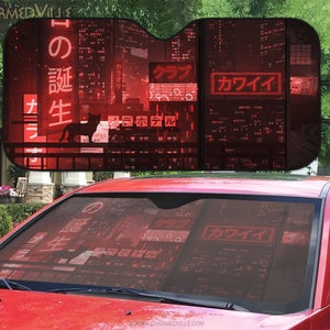 May include: Red and black car sunshade with a cityscape and Japanese text, including the words "カワイイ" and "の 誕生".