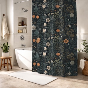 Puede incluir: Una cortina de ducha de color verde azulado oscuro con un estampado floral que presenta elementos botánicos blancos, naranjas y verdes. El diseño incluye flores, hojas y vainas de semillas estilizadas. La cortina cuelga en un baño con una bañera blanca y una alfombra de baño blanca.