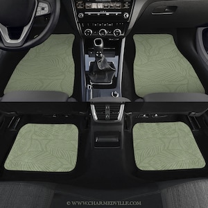 Puede incluir: Alfombrillas de coche verdes con un patrón de hojas. Las alfombrillas están hechas de un material duradero y están diseñadas para proteger el interior de tu coche de la suciedad y los derrames.