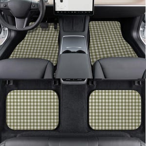 May include: A set of four car floor mats featuring a sage green and white gingham check pattern. The mats are installed in the front and rear footwells of a vehicle with a black interior, including the steering wheel and center console.