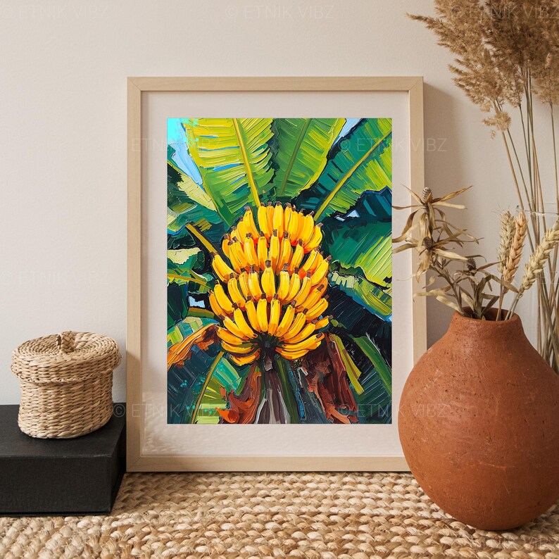 May include: A framed painting depicting a cluster of yellow bananas set against vibrant green leaves. The artwork is rendered in a textured, painterly style. The frame is a light wood colour, adding to the natural theme.