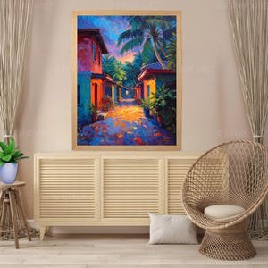 Pu&ograve; includere: Un dipinto a olio incorniciato raffigura una vivace scena di strada tropicale. Edifici nei toni del rosso, arancione e blu costeggiano un sentiero soleggiato, con palme sopra. L'opera d'arte &egrave; esposta sopra un mobile in legno chiaro.