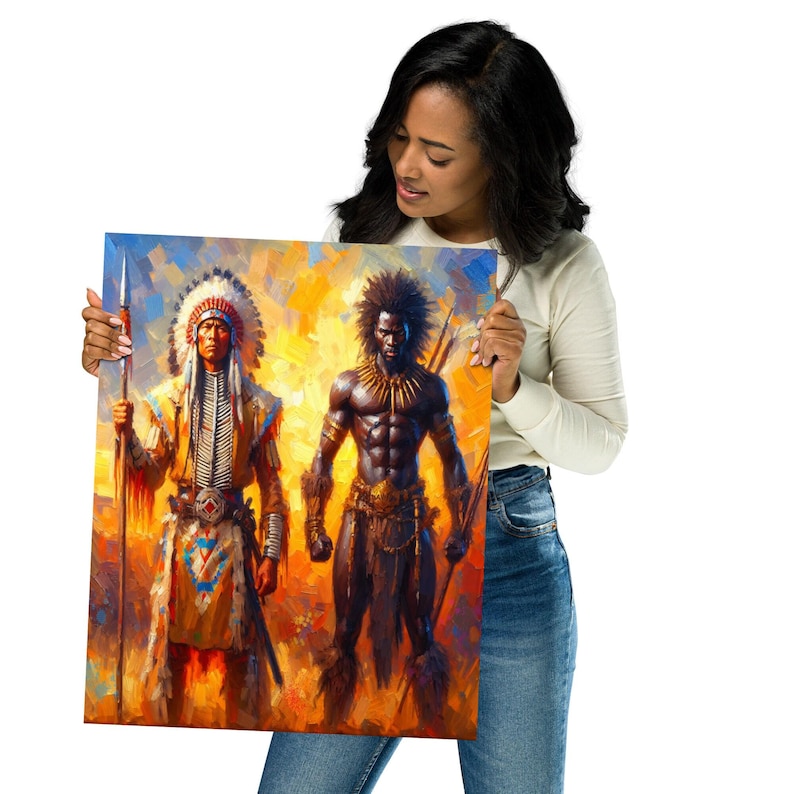 A smiling woman wearing a white long-sleeve shirt and jeans holds up a colorful art print of a Native American warrior and an African warrior.