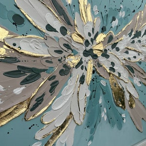Op de afbeelding: Abstract schilderij met een groot, gestileerd bloemmotief in tinten wit, goud en turquoise op een lichtblauwe achtergrond.