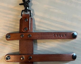 May include: Brown leather key chain with a black metal clip and two straps. The straps have black metal rivets and the top strap has the number 71001 embossed on it.