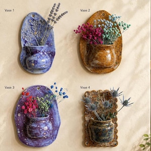 May include: Four ceramic wall-mounted vases labelled Vase 1 through Vase 4. Vase 1 is purple with lavender. Vase 2 is amber with pink and blue flowers. Vase 3 is mottled purple with pink and blue flowers. Vase 4 is brown with blue thistle flowers.